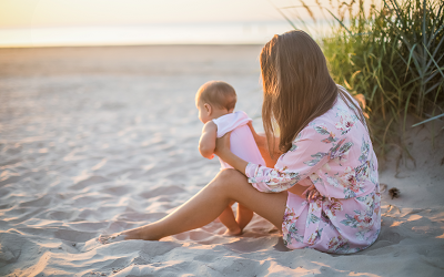 Frau mit kleinem Kind am Strand