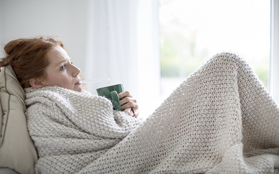 Frau mit Decke und Tasse