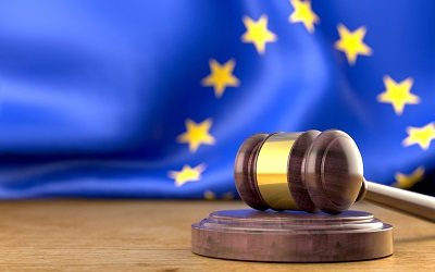 Gerichtshammer mit EU-Flagge im Hintergrund