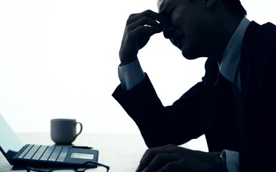 frustrierter Mann im Dunkeln vor Laptop