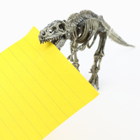 Ein Tyrannussaurierskelett hält eine leere Karteikarte im Maul