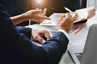 Menschen werten Daten an Tablet aus.