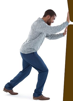 Mann hält braunen Block auf.