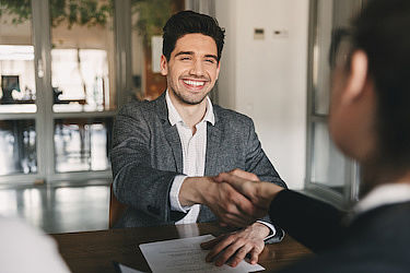 Bewerber schüttelt Interviewpartnerin die Hand.