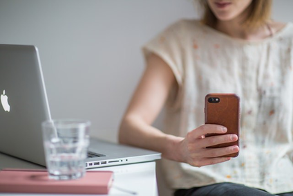 Junge Frau schaut auf ihr Smartphone