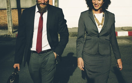 Ein Mann und eine Frau in Businesskleidung auf gleicher Höhe nebeneinander
