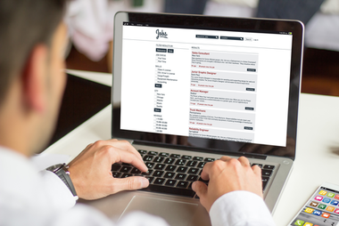Mann schaut an Laptop Online-Stellenangebote an