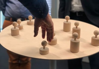 Hand verschiebt Figuren auf Tisch