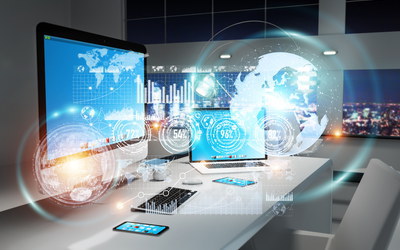 Bürostuhl vor Schreibtischen mit den Accessires eines digitalen Arbeitsplatzes