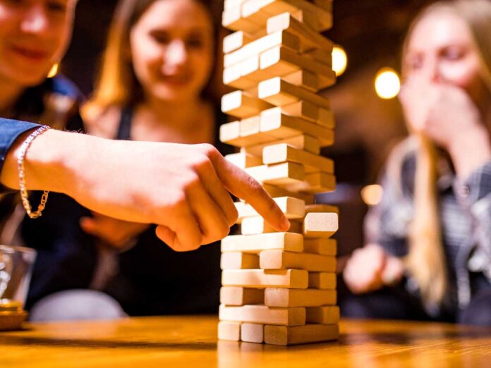 Drei junge Frauen spielen Jenga
