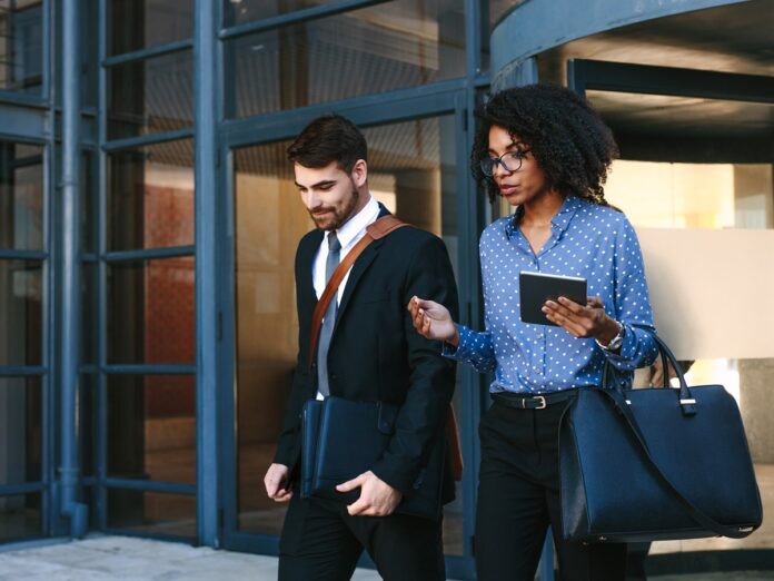 Beschäftigte verlassen Gebäude und machen Feierabend.